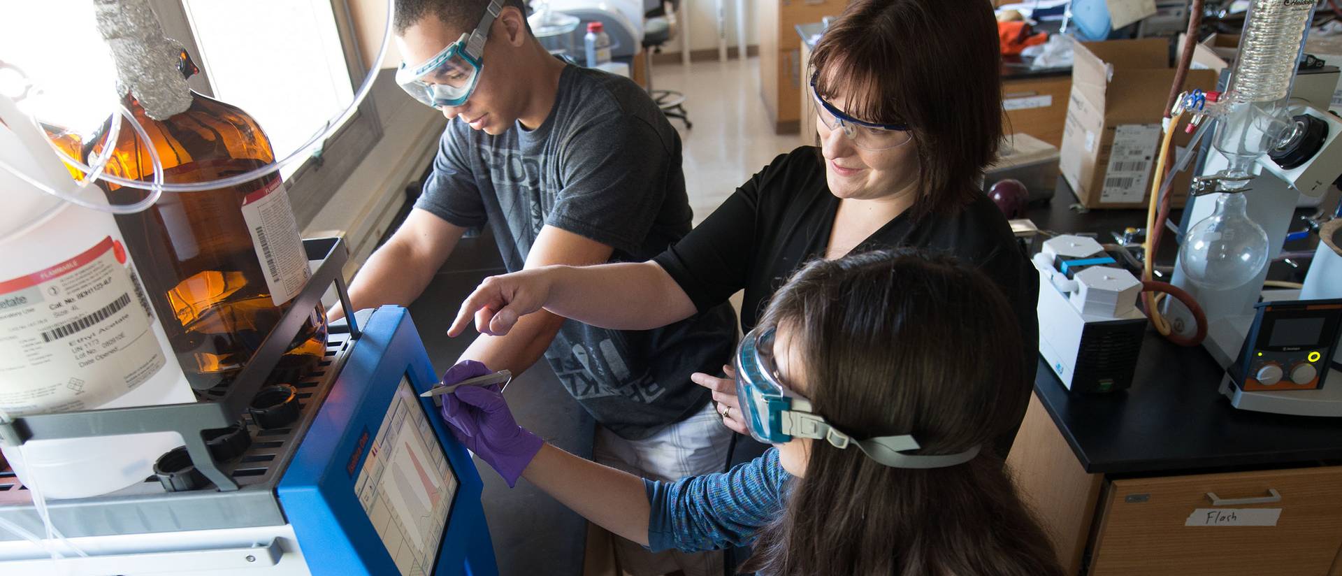 Tayo Sanders (left) works with research mentor Jennifer Dahl (middle), an assistant professor in materials science, on cross-linked gold nanoparticle films